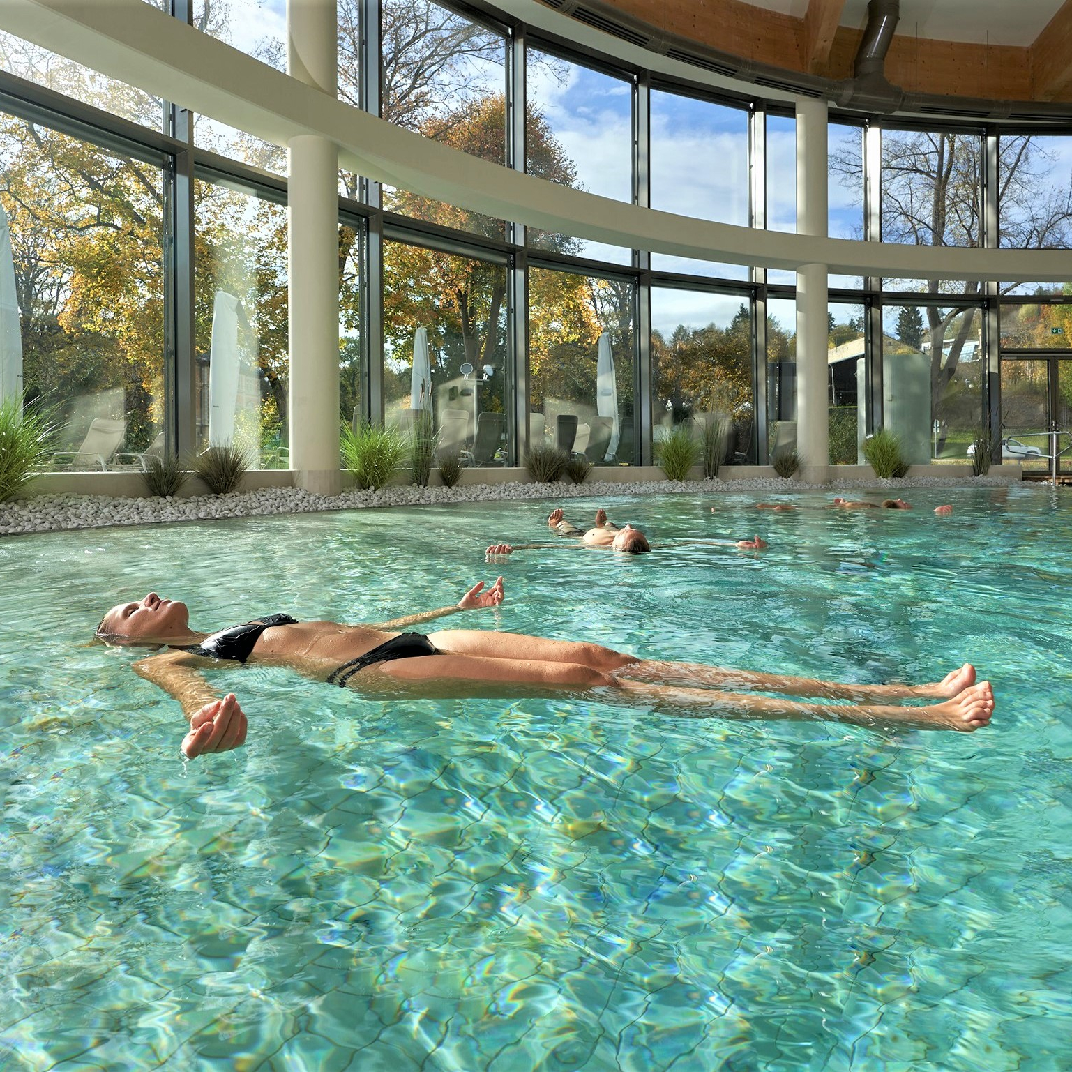 Eine Frau horizontal im Wasser schwebend im Solebad-Schwimmbecken