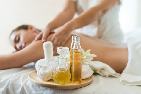 Eine Frau genießt mit geschlossenen Augen eine basische Salz-Öl-Massage