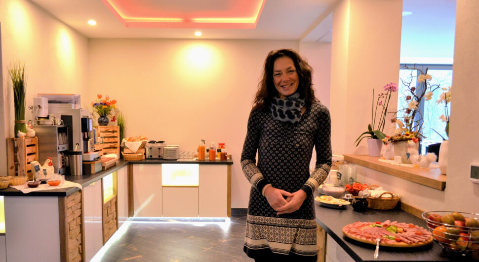 Eine lächelnde Frau steht mitten Buffet-Bereich