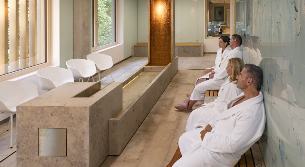 Je zwei Paare sitzen mit dem Rücken an der Wand im Radoninhalations-Raum