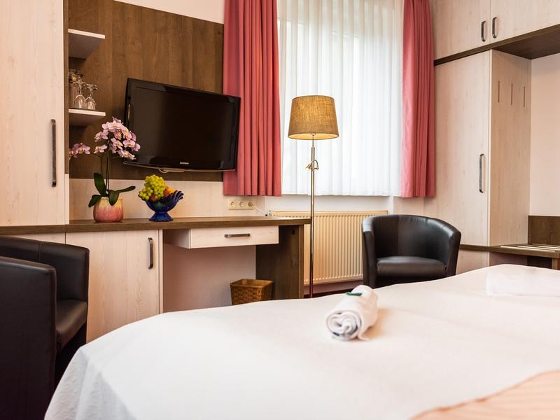 Goldner Anker Zimmeransicht über das Bett zum Schreibtisch