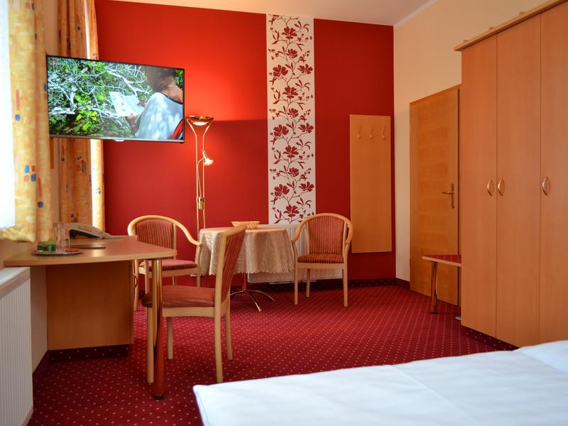 In rot gehaltene Zimmer-Detailansicht von Schreibtisch mit Fernseher und Sitzecke