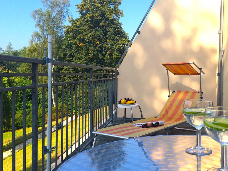 Zimmer-Terrasse mit Liege und einem Tisch auf dem zwei Gläser Wasser mit Limette stehen