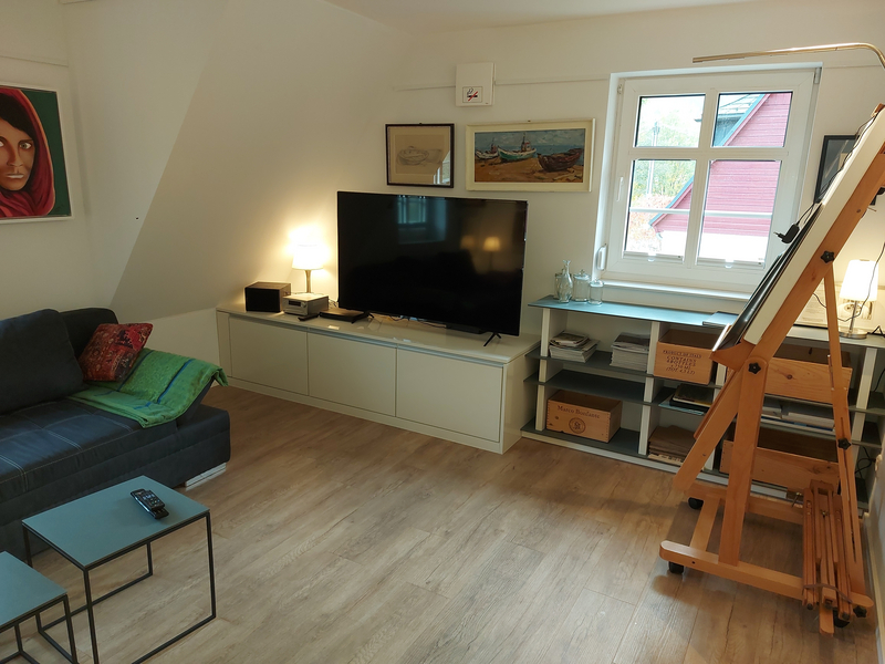 Wohnzimmer mit TV und einer offenen Kommode