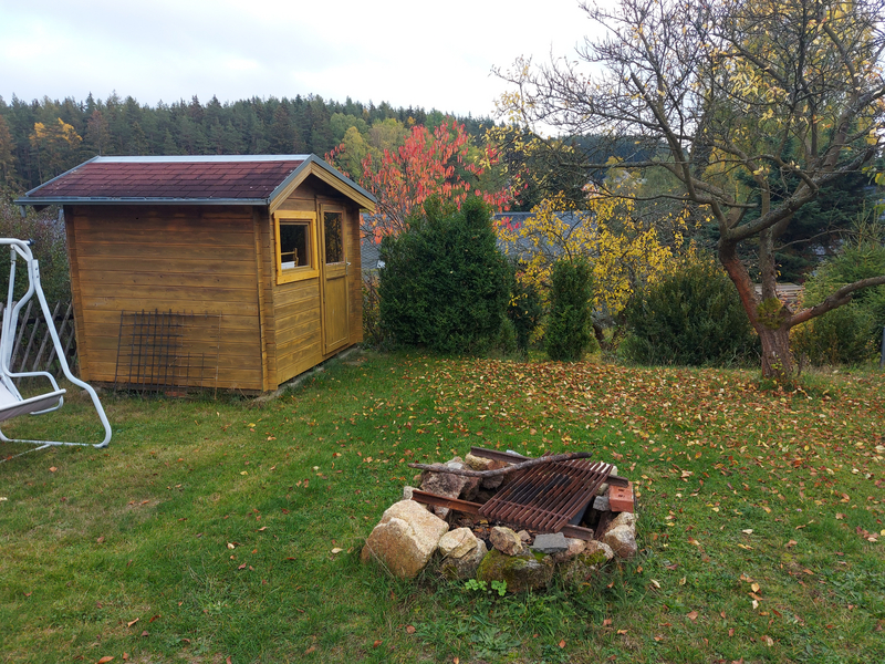 Feuerstelle mit Holzhütte im Garten