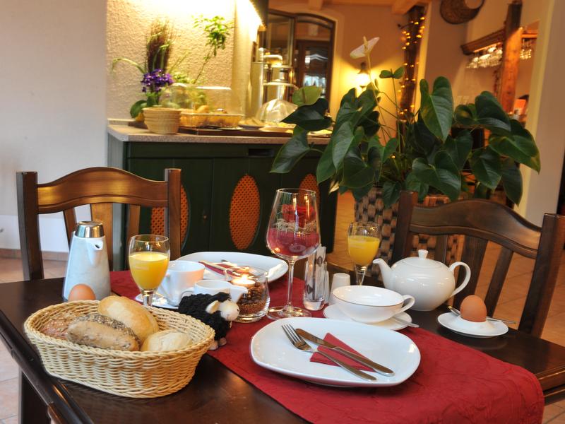 Hotel Garni "Obere Mühle" gedeckter Frühstückstisch mit Brötchen, Ei und Orangensaft