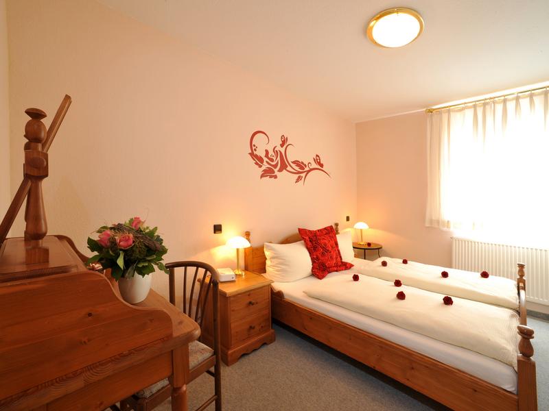 Hotel Garni "Obere Mühle" - Doppelbett mit Wandtattoo und kleinem Holzsekretär