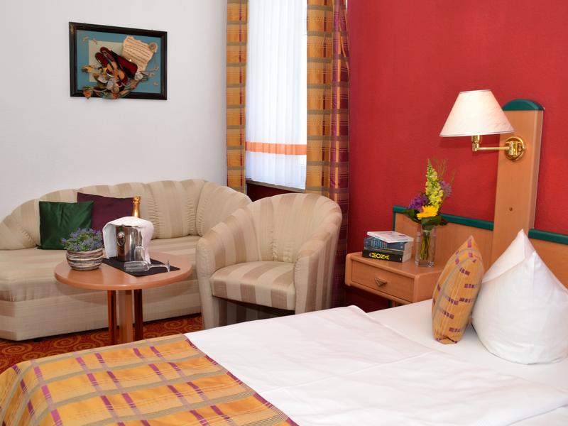 Parkhotel Helene Zimmerbeispiel mit Doppelbett und Sitzecke