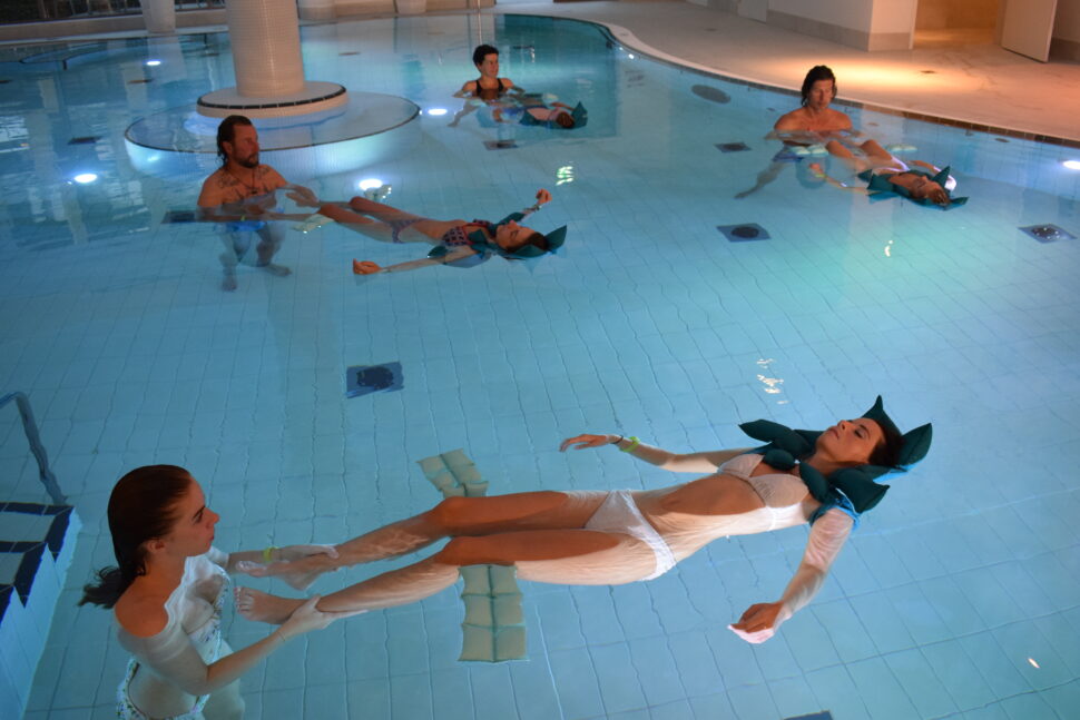 Mehrere Paare im Thermalbad und je eine davon liegt schwebend im Wasser