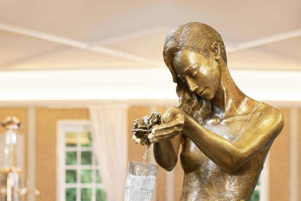 Frauenstatue aus der Wasser in ein Glas läuft