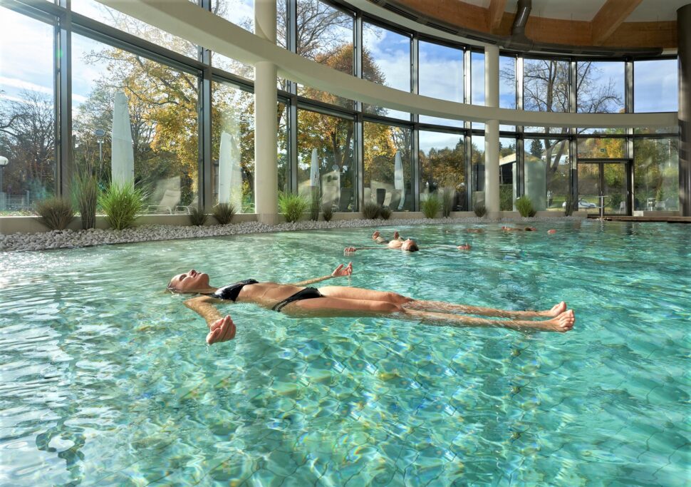 Eine Frau liegt horizontal schwebend im Sole-Therme-Becken